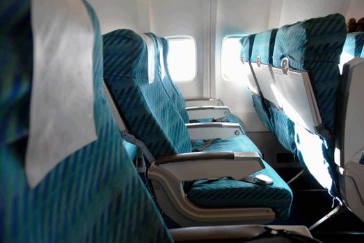 row of blue seats indoors in passenger airplane