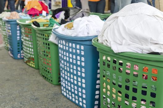 A line of laundry baskets full of dirty clothes for washing