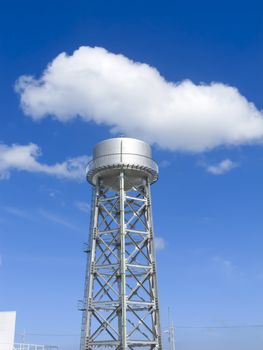 Water tank in an industrial plant shot against blue sky