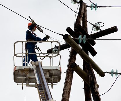 Electric is working on a pole in a special lift vehicles