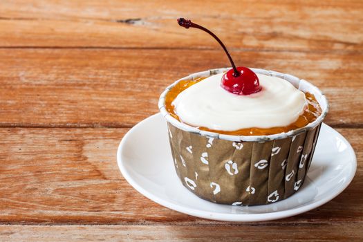 Butter Marmalade Cupcake decorated with red cherry