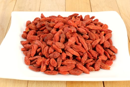 red goji fruits over white plate