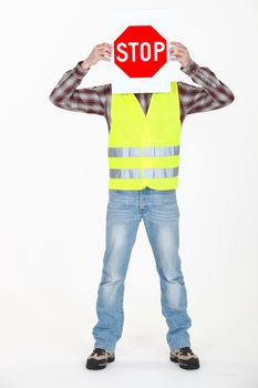 Builder covering face with stop sign