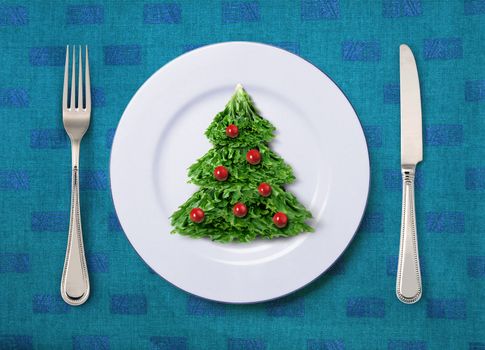 Christmas salad on white plate with knife and fork