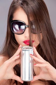Pretty woman with sun glasses holding can with both hands