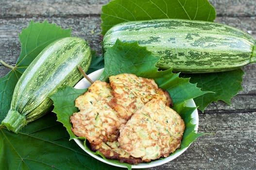 Pancakes with fresh zucchini on grape leaves