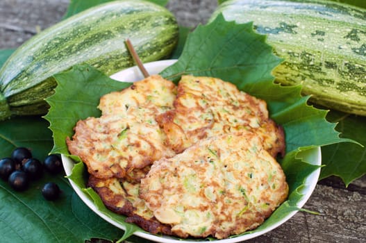 Pancakes with fresh zucchini on grape leaves