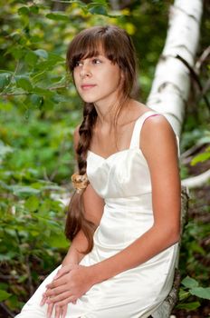 Russian girl in a white dress in a birch forest