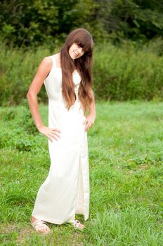 Teenage girl in a white dress on the nature