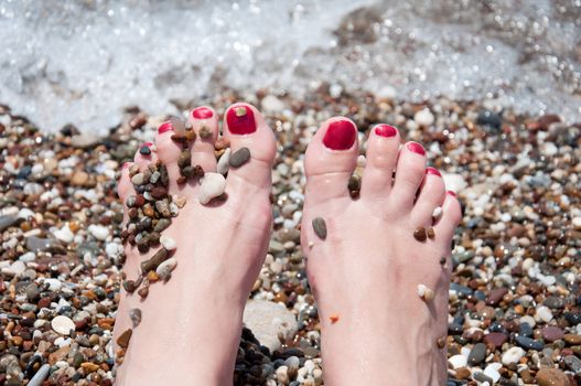 Female feet on a background of sea water