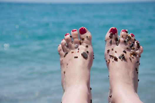 Female feet on a background of sea water