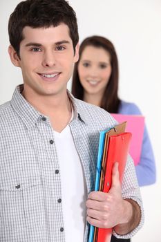 young student all smiles holding files and girl in background