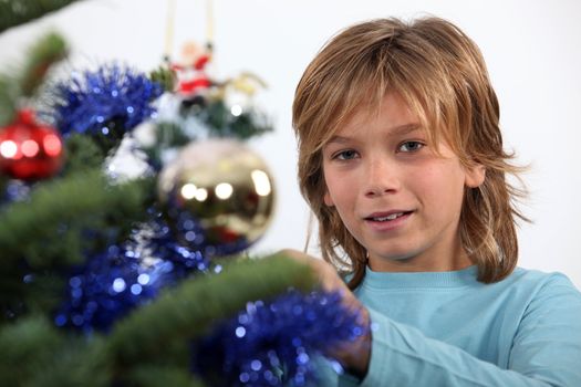 Prepubescent boy decorating a Christmas tree