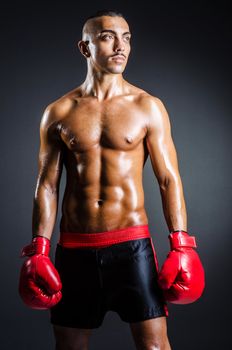 Boxer with red gloves in dark room