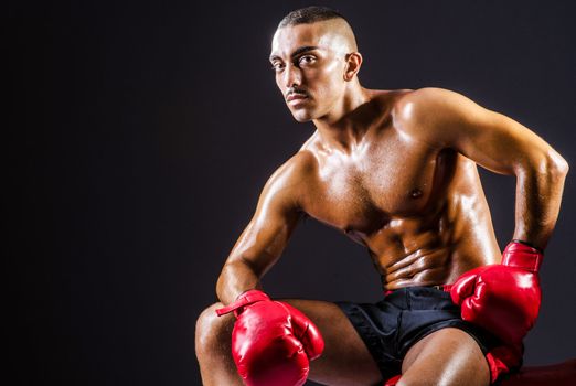 Boxer with red gloves in dark room