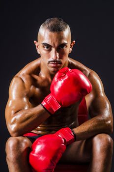 Boxer with red gloves in dark room