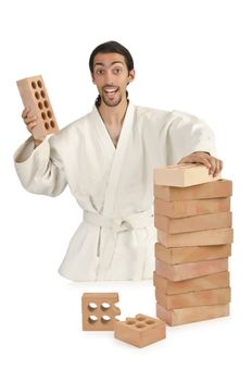 Karate man breaking bricks on white