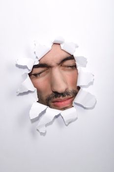 Male face through the hole in paper