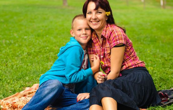 Mother and son play outside on field in the park