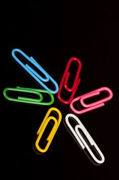 photo of colorfull paper clips on a black background