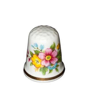 White china thimble with flowers painted isolated against white