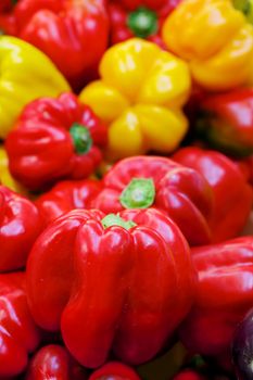Red and Yellow Bell Peppers at the farmers market with sharp focus on center vegetable