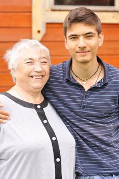 Happy grandmother and grandson in front of house