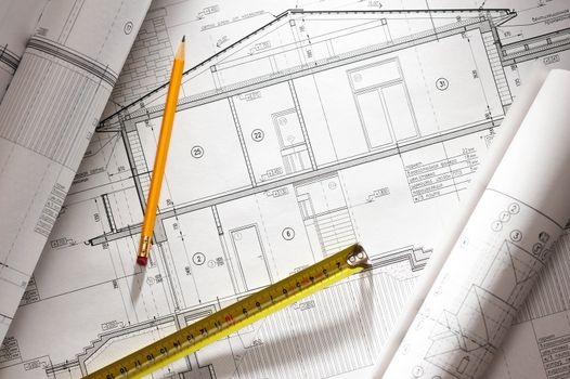 Pencil and tape meausure over house plan blueprints