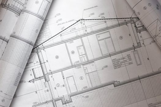 House plan blueprints roled up over table