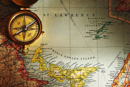 Antique brass compass over old Canadian map background