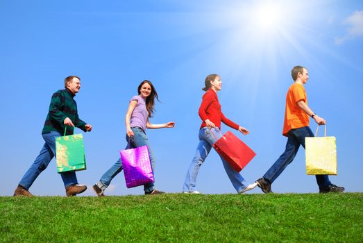 People with bags against blue sky