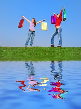 Girls with bags against blue sky with reflection on water
