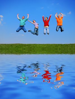 People jumping against blue sky with reflection on water