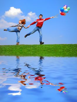 Couple with balloons against blue sky with reflection on water