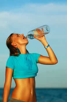 Woman drinking water after jogging