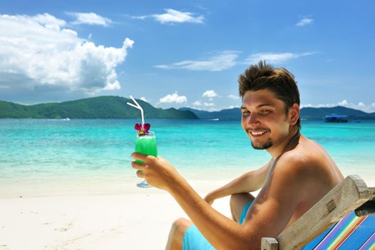 Man on a beach with cocktail