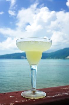 Margarita cocktail with sea and sky in background