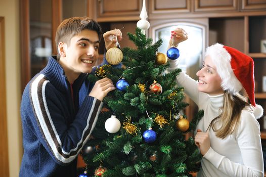 Young couple decorating christmas tree