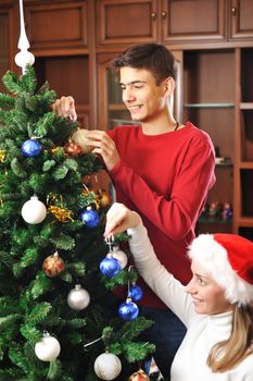 Young couple decorating christmas tree