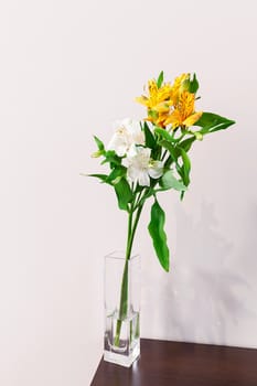 White and yellow alstroemeria flowers in the vase on the table