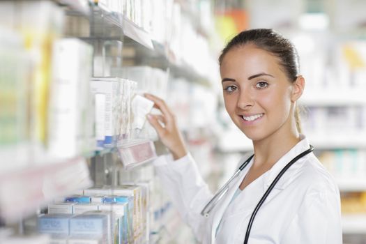 Portrait of a young female pharmacist selecting a medication