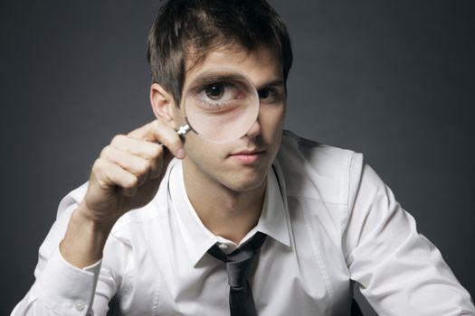 businessman looking through a magnifying glass