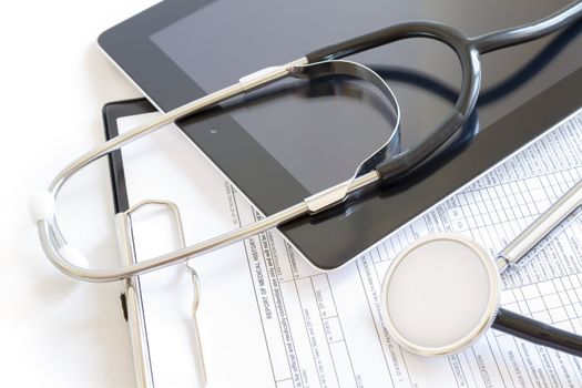 Digital tablet with stethoscope and paperwork