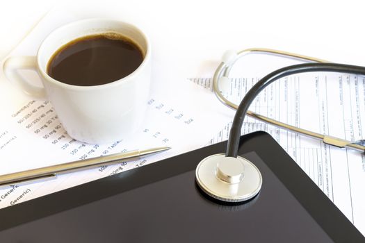 Digital tablet with stethoscope and paperwork