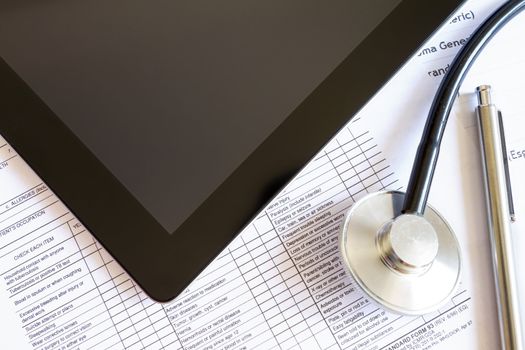 Digital tablet with stethoscope and paperwork