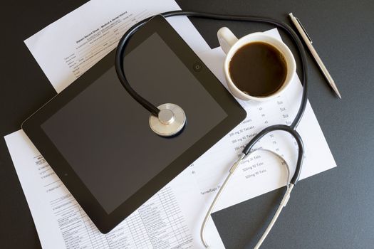 Digital tablet with stethoscope and paperwork