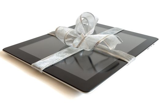 Digital tablet with silver ribbon gift isolated on white.