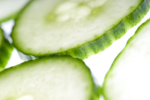 Defocus green cucumber slices macro in white studio