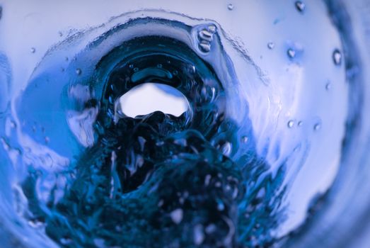 Pure blue fluid in a bottle swirling outwards