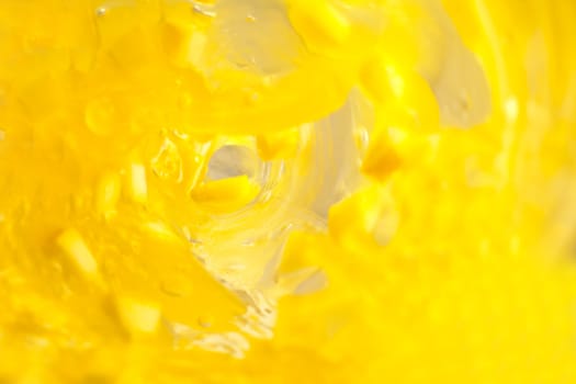 Steady flow of yellow liquid with chunks through a bottle